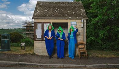 three women stood outside a bus stop