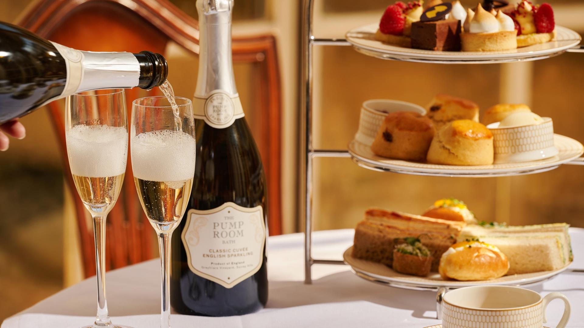 An afternoon tea and two champagne flutes on a table at The Pump Room Restaurant in Bath.