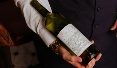 A bottle of red being presented 