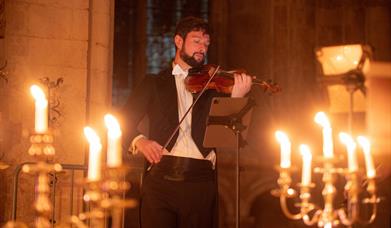 Violinist surrounded by candles