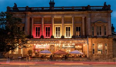 Exterior view of Green Park Brasserie and Bath Pizza Co by night. 