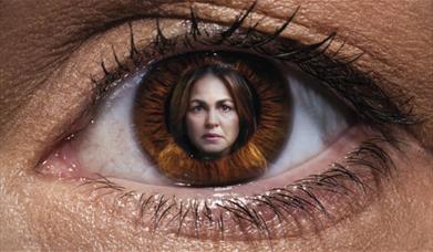 A large eye is displayed with a concerned woman's face. 