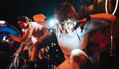Dancers in the dark, wearing lights on their hands
