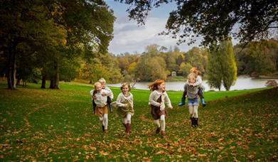 Children running through the grounds at Bowood House & Gardens in autumn