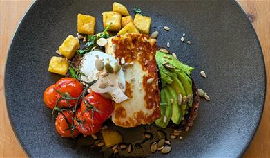 A bowl of avocado, tomato and halloumi