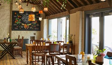 A large open pub with wooden tables and chairs 
