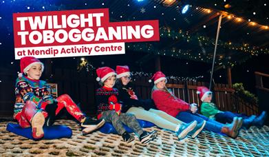 Family wearing festive clothing and enjoying Twilight Tobogganing at Mendip Activity Centre