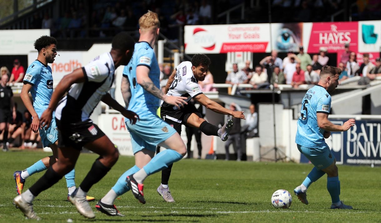 A Bath City football player kicking the ball