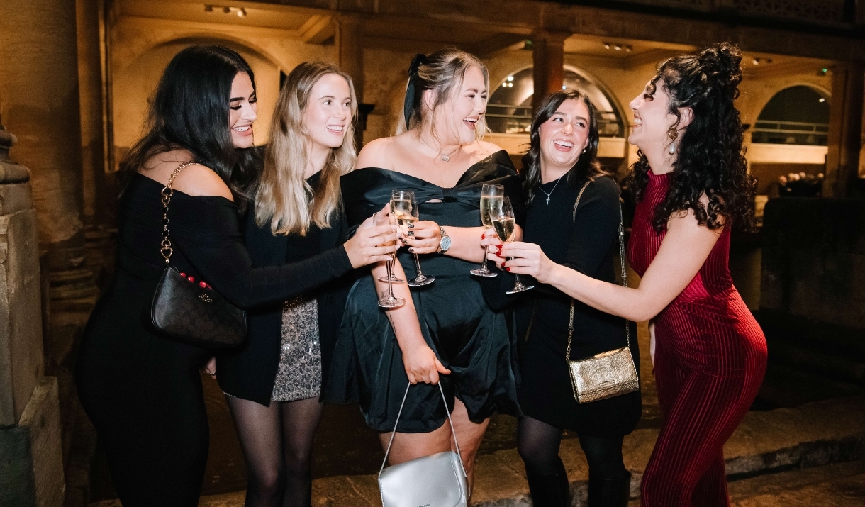 Party-goers cheers around the Roman Baths at Christmas
