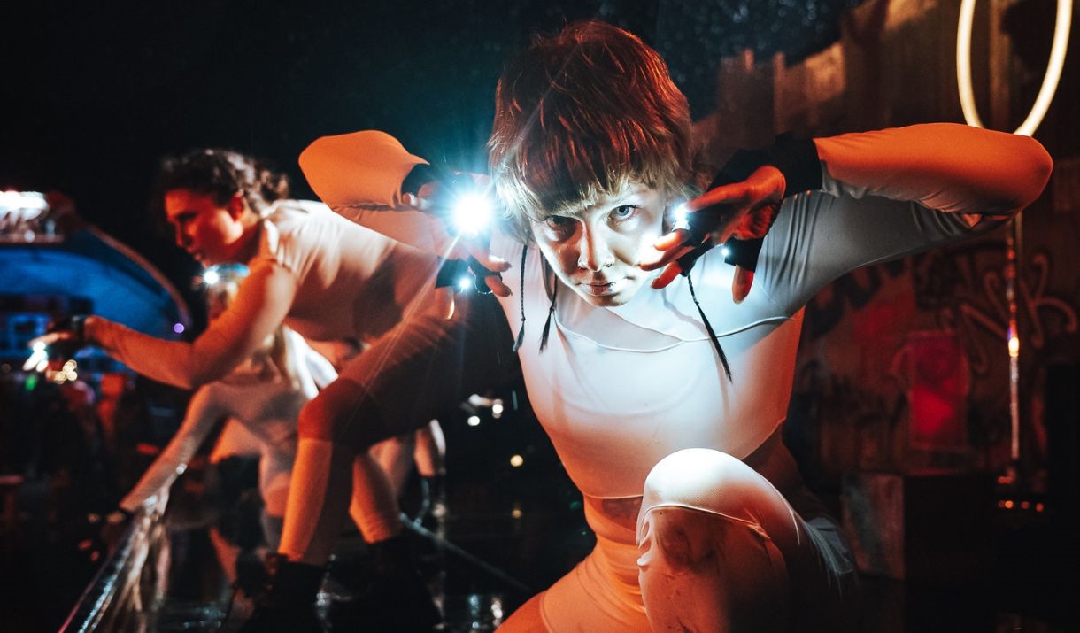 Dancers in the dark, wearing lights on their hands