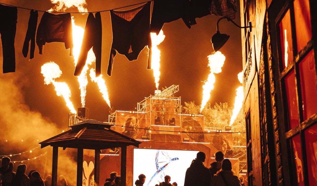 Fire show at Avon Valley FEAR event, with jets of flame erupting from the top of a tall stage in several directions.