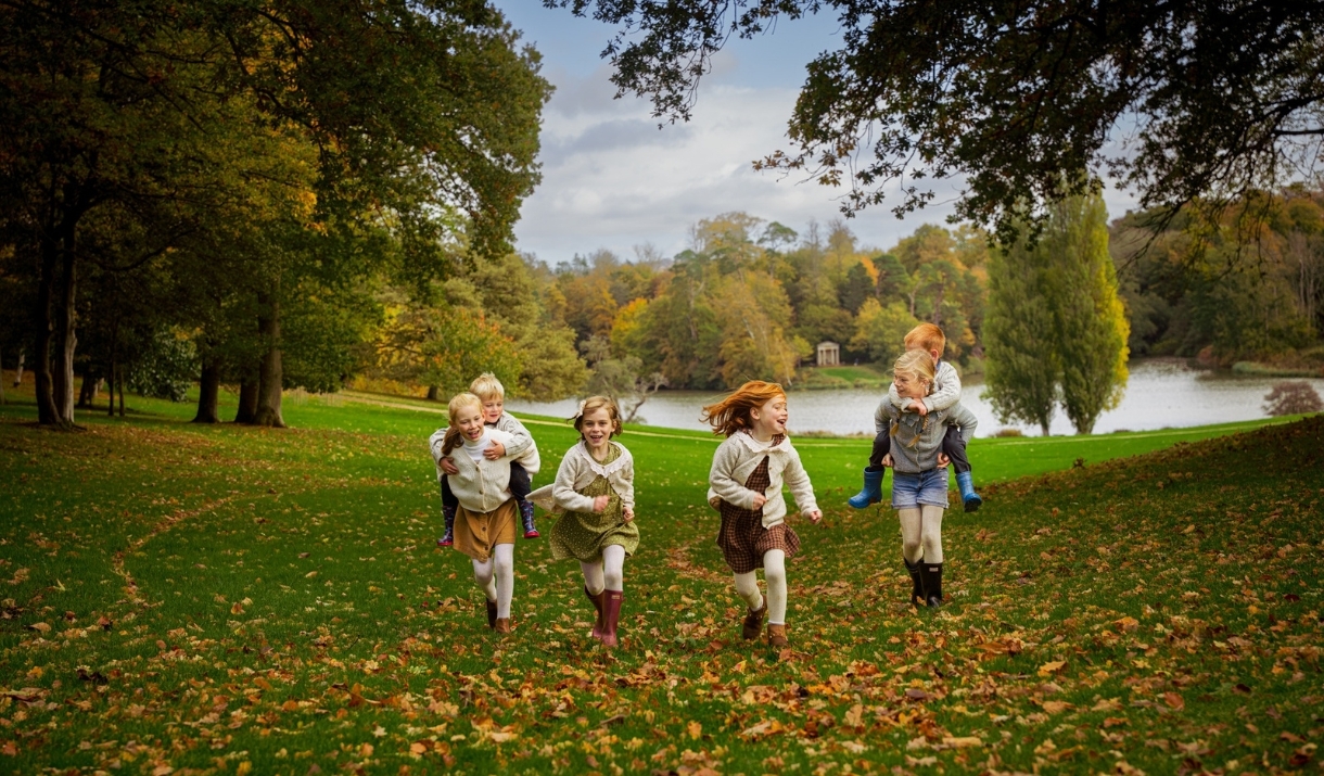 Children running through the grounds at Bowood House & Gardens in autumn