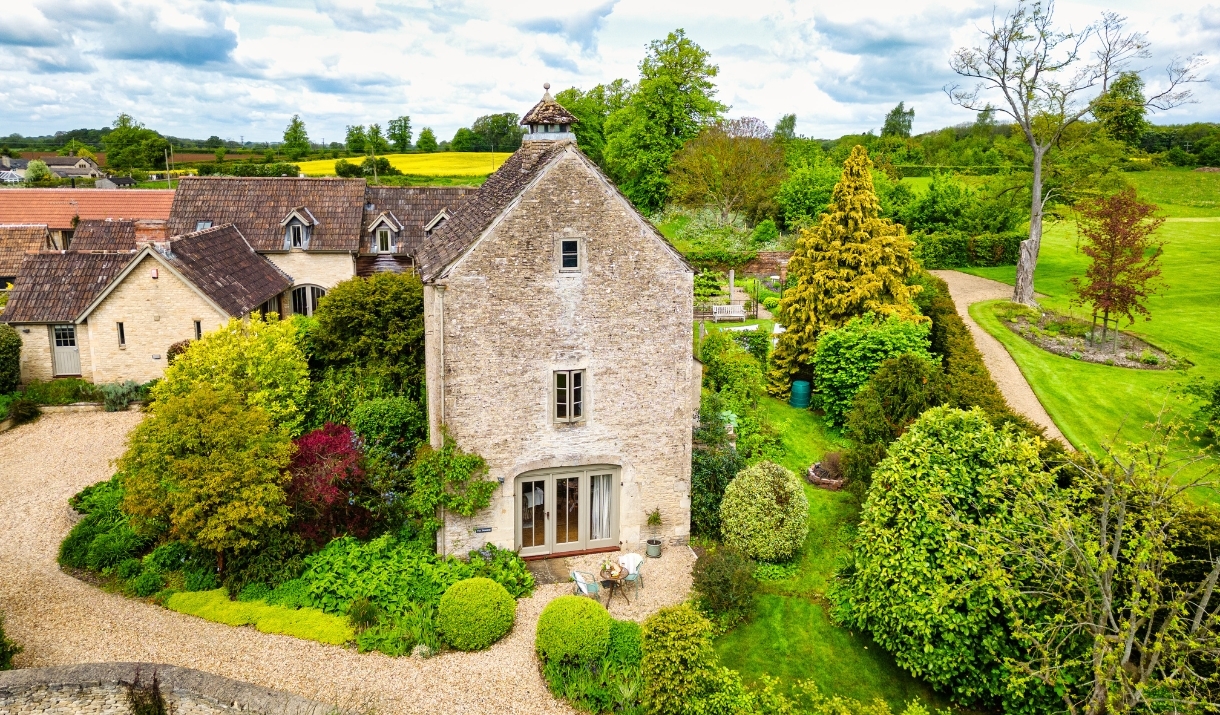 Dovecote Cottage's exterior surrounded by nature and forestry.