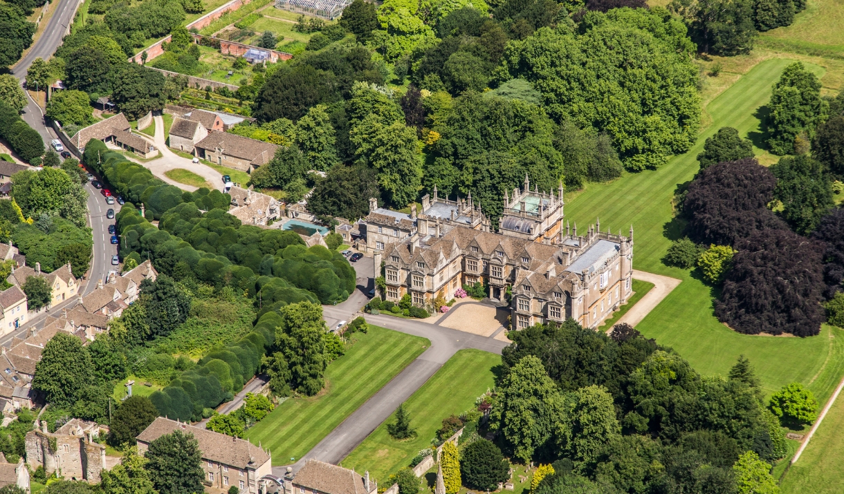 Aerial view of Corsham Court - a grand estate in lawned grounds.