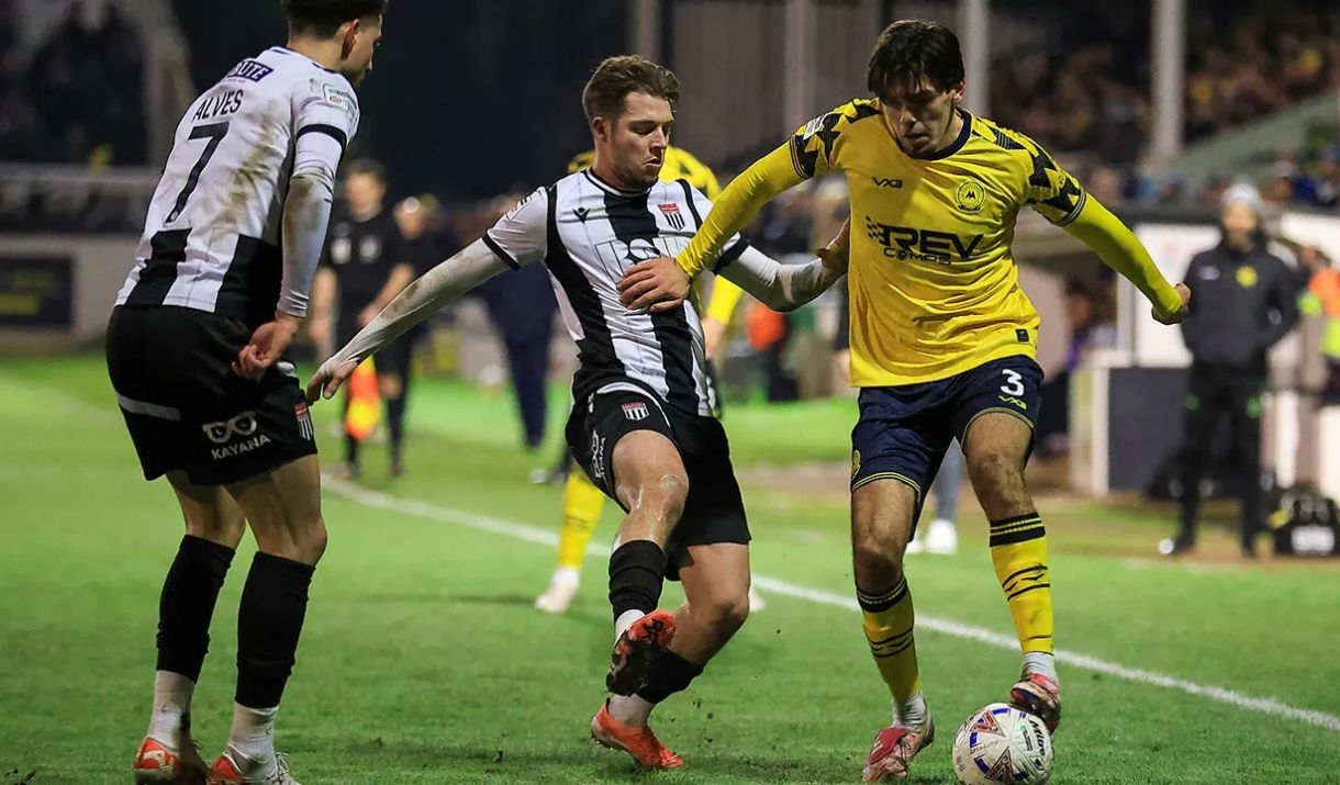 A Bath City football fighting another player for the ball