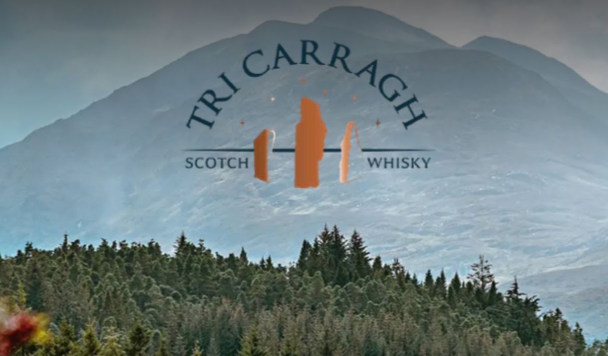 A image of a scottish valley with trees in the foreground and a mountain in the back ground.