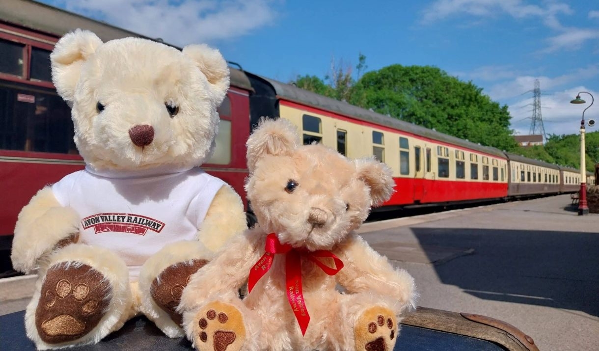 2 teddy bears at Avon Valley Railway sat in front of an old fashioned train