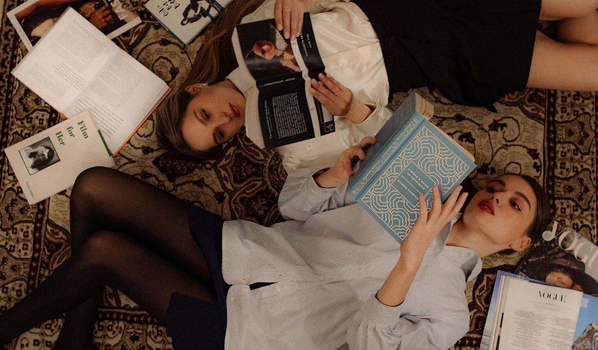 Woman wearing a cream Lutea Studios blouse in a warm interior setting.