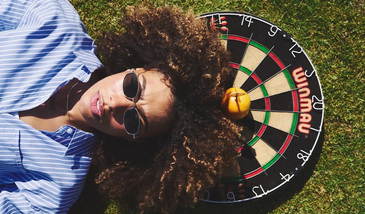 Person lying down on top of a dart board