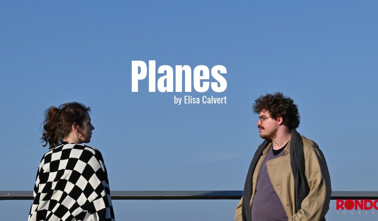 A young man and woman stood against a blue sky. The play's title, 'Planes' hovers in stark white writing between them.