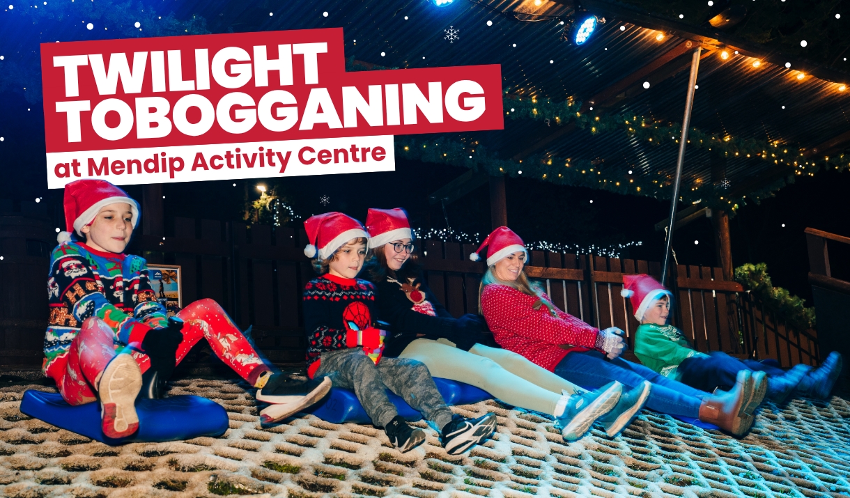 Family wearing festive clothing and enjoying Twilight Tobogganing at Mendip Activity Centre