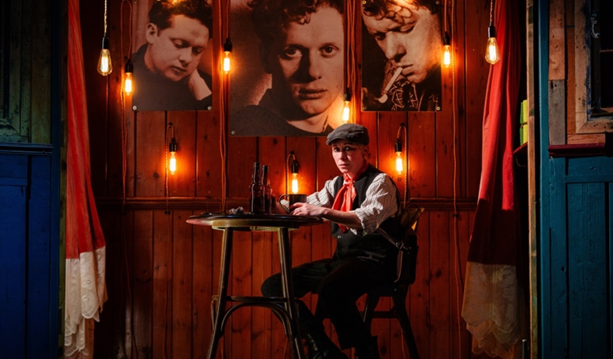 A person sits down at the table, it's nighttime, with photographs above.