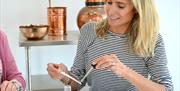 A woman uses a pipette to put fragrance on a scent tester stick
