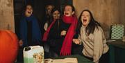 A group of teenage girls screaming while smiling in a creepy room.