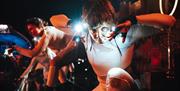 Dancers in the dark, wearing lights on their hands