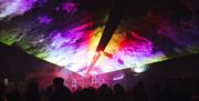 Lasers projecting an image of multi-coloured clouds above the heads of the audience.