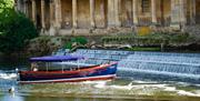 The Jolly Brit boat sailing on Pulteney Weir in the River Avon