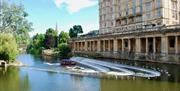 The Jolly Brit boat siling towards Pulteney Weir on the River Avon
