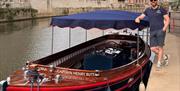 Captain Henry Butt leans against his boat, The Jolly Brit, while docked in Bath.
