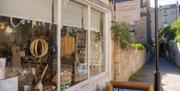 The exterior of The Bertinet Kitchen, with large windows displaying an array of baked goods and kitchen equipment.