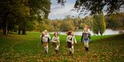Children running through the grounds at Bowood House & Gardens in autumn