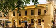 The exterior of The Crystal Palace, a pub with yellow walls and gold lettering above the entrance.