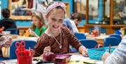 Girl working on a craft project at a table in the Victoria Art Gallery