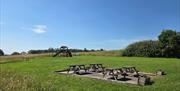 A field with countryside views and tables and chairs and a a small kids play area