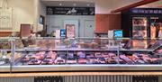 A deli counter of meats inside the Flourish farm shop