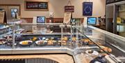 A deli counter of cheeses inside the Flourish farm shop