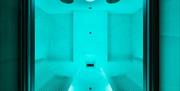 CLAFFS thermal ritual treatment room with a bench on either side, and with vibrant blue lighting.