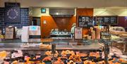 A deli counter full of sausage rolls and goodies