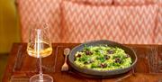 A glass of white wine and a plate of food at Iford Manor Kitchen