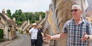 Image of people taking a photo in a village in the Cotswolds photoshopped alongside an image of a tour guide presenting to their group in an abbey or