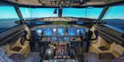 Interior of a jet flight simulator with faux windows displaying an airport runway