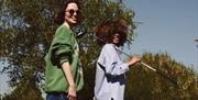 People walking and smiling with golfing equipment