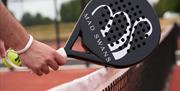 Hand holding a Padel racket, pala, there's some debate about the term apparently