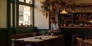 Interior of the Marlborough with tables being set and the bar behind