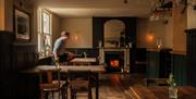 Another interior shot of tables being set and a lit fireplace