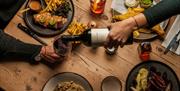 Plates of food and wine being poured